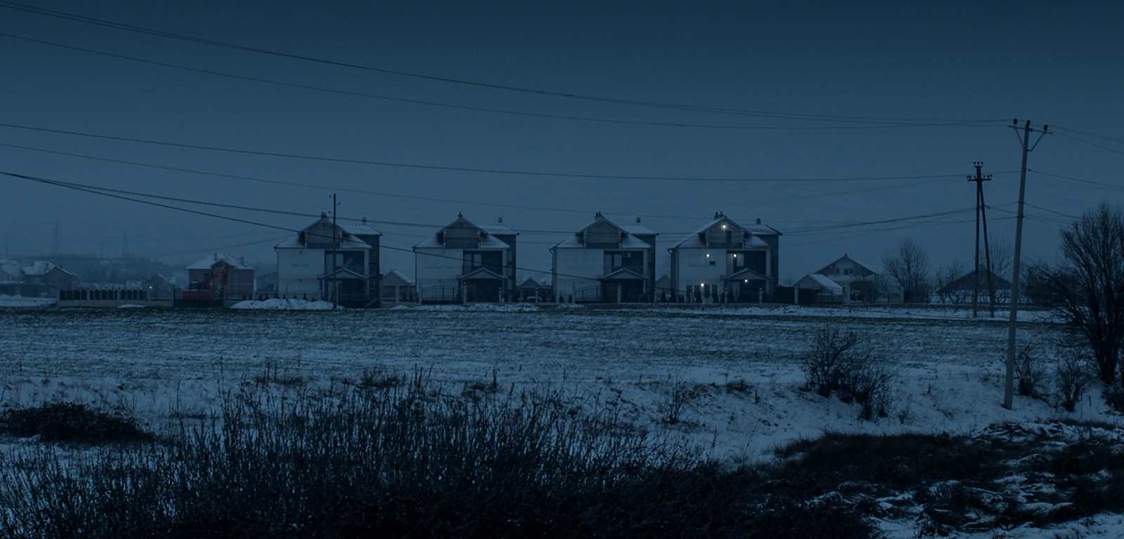 Dark winter landscape in snow, four identical houses in the background