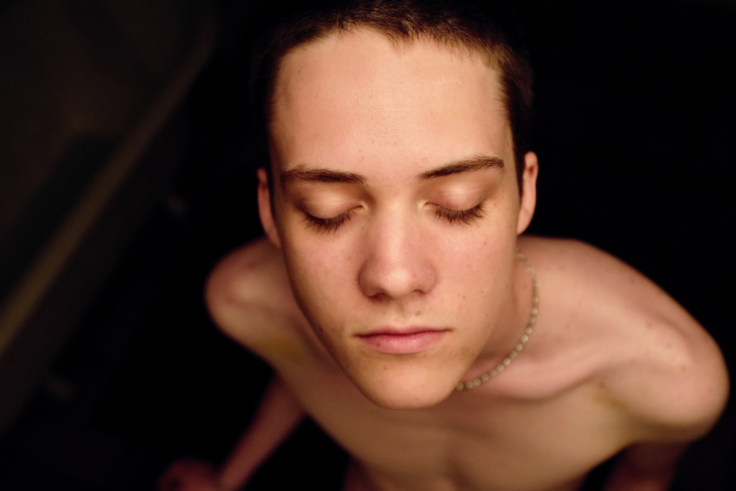 Young naked person with closed eyes